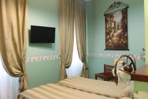 una camera da letto con un letto e una televisione a parete di Hotel Belle Epoque a Sanremo