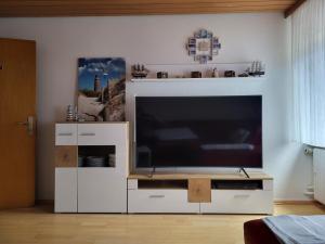 a large white entertainment center with a large flat screen tv at Am Kanal in Neuhaus an der Oste