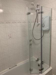 a shower with a glass door in a bathroom at Squirrel Away At Leven House in Crieff