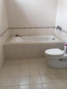 a bathroom with a bath tub and a toilet at HomesHue in Hue +16 photos