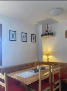 uma sala de jantar com uma mesa de madeira e cadeiras em Residenze Ca del bosco Piancavallo em Piancavallo