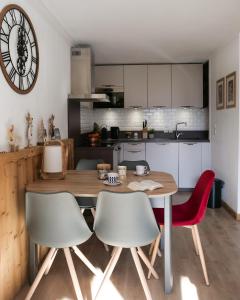 a kitchen with a wooden table and two chairs at Mont Blanc 43, vue Mont Blanc , balcon, parking in Chamonix-Mont-Blanc