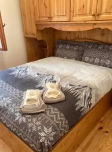 a bed with two towels sitting on top of it at Residenze Ca del bosco Piancavallo in Piancavallo