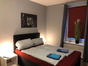 a small bedroom with a bed with a blanket at Flensburg City - 24h in Flensburg