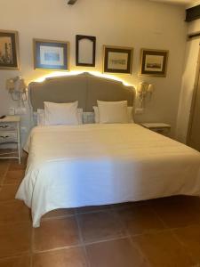 1 cama blanca grande con 2 almohadas en Apartamentos Sharis, en Jerez de la Frontera