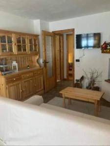 a kitchen with wooden cabinets and a wooden table at Residenze Ca del bosco Piancavallo in Piancavallo