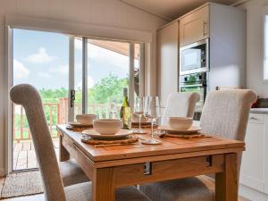 a dining room with a wooden table and chairs at The Alpaca Lodge in Arlecdon