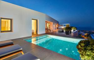 een zwembad in het midden van een huis bij Kamini Santorini Villas in Pirgos