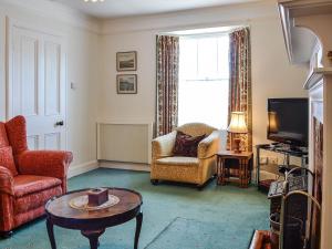 a living room with a couch and a table and a tv at St Enodoc in Ullapool