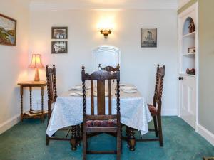 comedor con mesa, sillas y lámpara en St Enodoc, en Ullapool