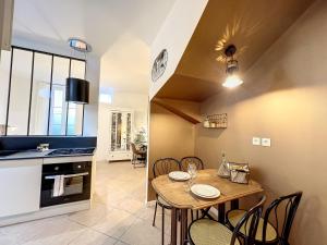 a kitchen and dining room with a table and chairs at Studio LA RECYCLERIE - Maison 1911 - confort & prestige in Gien