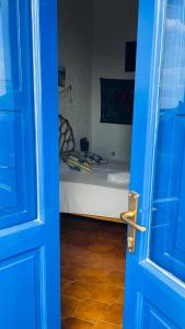a blue door leading to a bedroom with a bed at Perla Salina in Leni