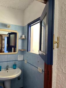 baño con lavabo y ventana en Perla Salina, en Leni