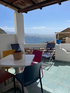 una mesa y sillas en un balcón con vistas al océano en Perla Salina, en Leni
