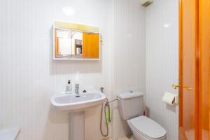 a white bathroom with a toilet and a sink at Mtsrat8 in Torrevieja +13 photos