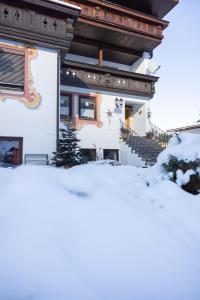 una casa con nieve delante en Pension Gulla - Ferienhaus Appartements B&B, en Neustift im Stubaital