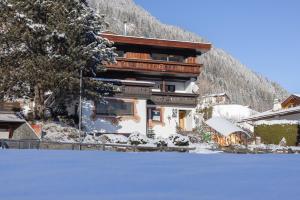 ein Gebäude mit Schnee auf dem Boden davor in der Unterkunft Pension Gulla - Ferienhaus Appartements B&B in Neustift im Stubaital