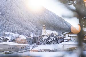 a small town with a church in the snow at Pension Gulla - Ferienhaus Appartements B&B in Neustift im Stubaital