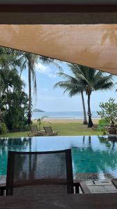 a pool with a view of the beach and the ocean at Absolute Beachfront Pool Villa in Ko Chang