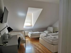 a room with a bed and a desk and a window at Rooms Sincere 1830 in Ljubljana