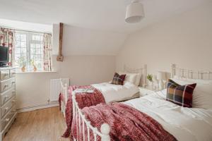 a bedroom with two beds and a tv in it at Garth Cottage in West Ayton in Scarborough