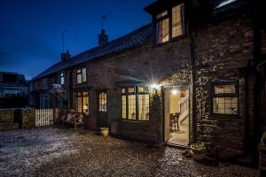 a brick house with a lit up door at night at Garth Cottage in West Ayton in Scarborough