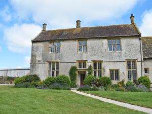 uma antiga casa de pedra com um quintal verde em The Farmhouse em Holwell