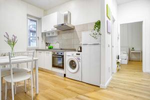 a kitchen with a washer and dryer next to a table at ALTIDO Warm and Inviting flat with balcony in Milan