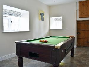 a room with a pool table with apples on it at The Farmhouse in Holwell