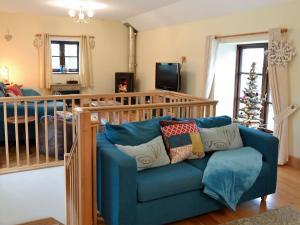 a living room with a blue couch and a christmas tree at Trevellyan Barn in Lanivet