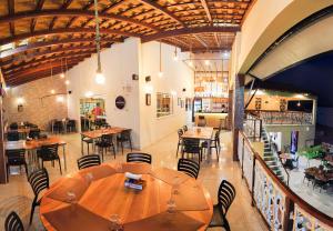 a restaurant with a large wooden table and chairs at Premium Hotel in Mombaça