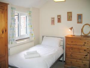 a bedroom with a bed and a window and a dresser at The Granary in Knapton