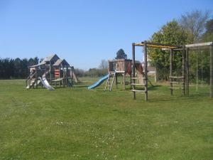 a group of playground equipment in a grass field at The Granary in Knapton