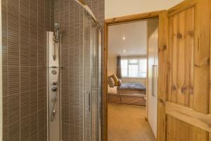 a bathroom with a walk in shower next to a bedroom at Birch 23 Hot Tub in Garton