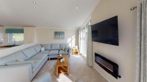 a living room with a couch and a flat screen tv at Beech 26 Hot Tub in Garton