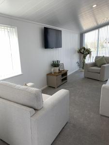 a living room with a couch and a flat screen tv at Cherry Blossom 42 Hot Tub in Garton