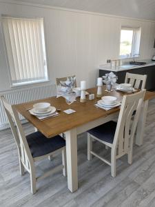 a wooden table with chairs and a dining room at Cherry Blossom 42 Hot Tub in Garton