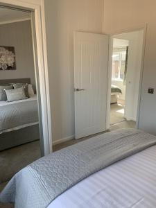 a bedroom with a bed and a door leading into a room at Cherry Blossom 42 Hot Tub in Garton
