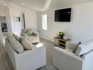 a living room with two couches and a flat screen tv at Cherry Blossom 43 Hot Tub in Garton