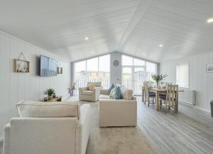 a living room with white furniture and a dining room at Cherry Blossom 48 Hot Tub in Garton