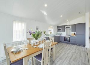 a kitchen and dining room with a wooden table and chairs at Cherry Blossom 48 Hot Tub in Garton