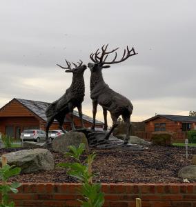 a statue of two reindeer jumping in a yard at Cherry Blossom 48 Hot Tub in Garton