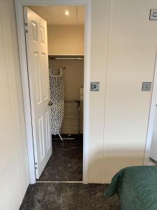 a bedroom with a door open to a closet at Elm 34 Hot Tub in Garton