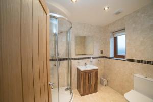 a bathroom with a shower and a sink at Hawthorn 19 Hot Tub in Garton