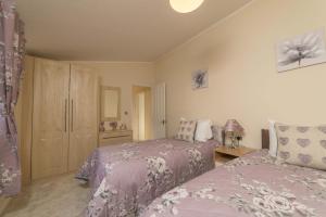 a bedroom with two beds and a cabinet at Birch 24 Hot Tub in Garton