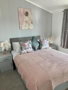 GartonにあるElm 35 Hot Tubのベッドルーム1室(ピンクの掛け布団と枕付きのベッド1台付)