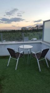 dwa krzesła i stół na balkonie z widokiem w obiekcie Ático,loft ,duplex w Madrycie