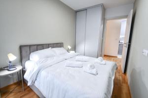 a bedroom with a large white bed with towels on it at Petar's aparment luxury new in Skopje
