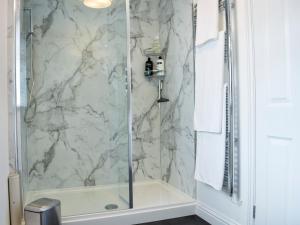 La salle de bains est pourvue d'une douche avec une porte en verre. dans l'établissement Riverside, à Mevagissey