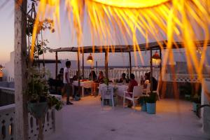 a group of people sitting at tables under a gazebo at Dar Evelyne in Mahdia